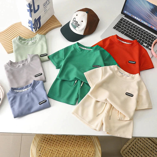 طقم مكون من قطعتين من السراويل القصيرة بأكمام قصيرة للأطفال في الصيف، ملابس أطفال للأولاد والبنات، تي شيرت، بنطلون، بدلات رياضية بألوان سادة من سن 1 إلى 8 سنوات